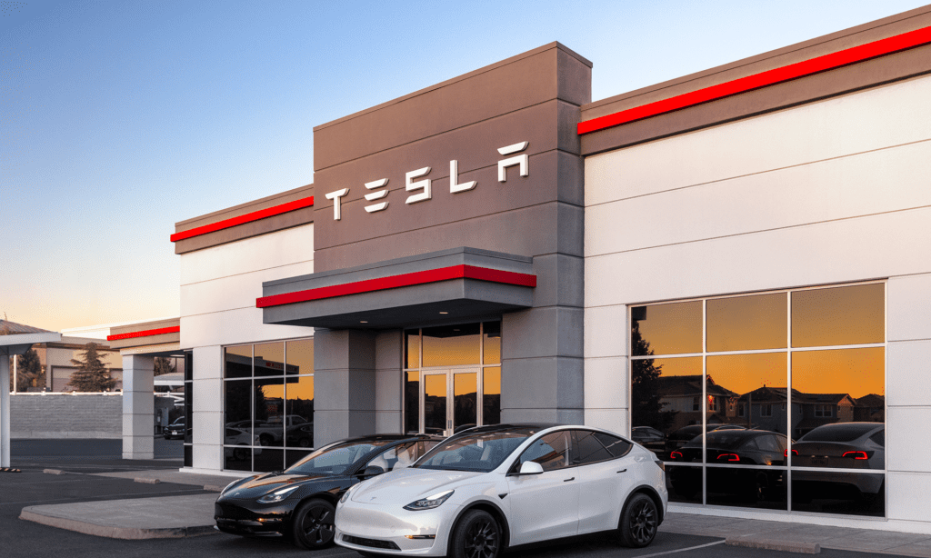 A Tesla Dealership With Two Tesla Electric Vehicles Parked Out Front.png