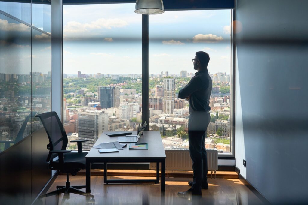 Ey Silhouette Of Businessman Standing In Office With Big City Capital Urban View.jpg